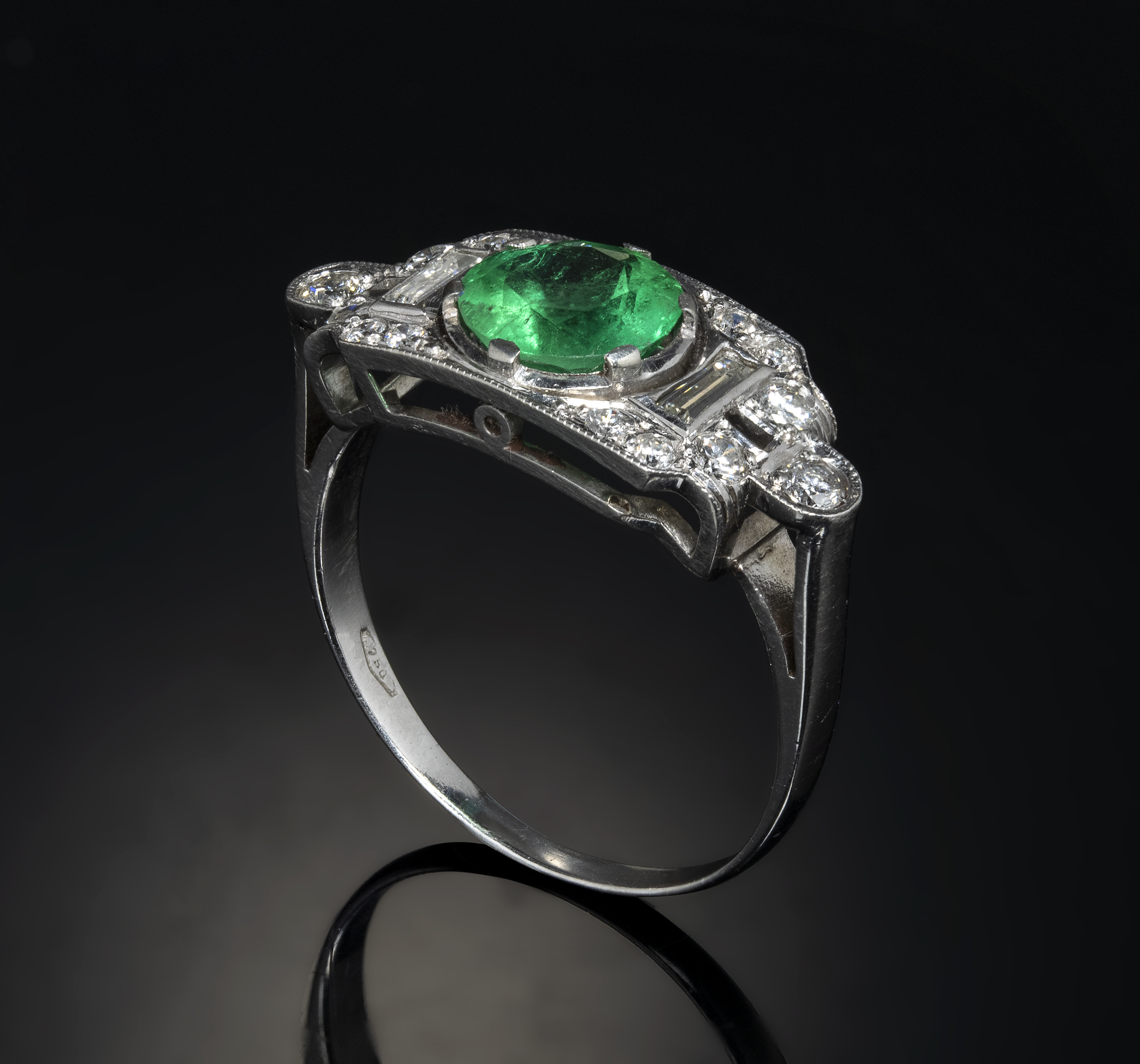 A 1940 platinum ring with diamonds and emerald.